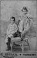 Picture relating to Toowoomba - titled 'Portrait of two children posing on a cane chair, Toowoomba, 1890-1900'